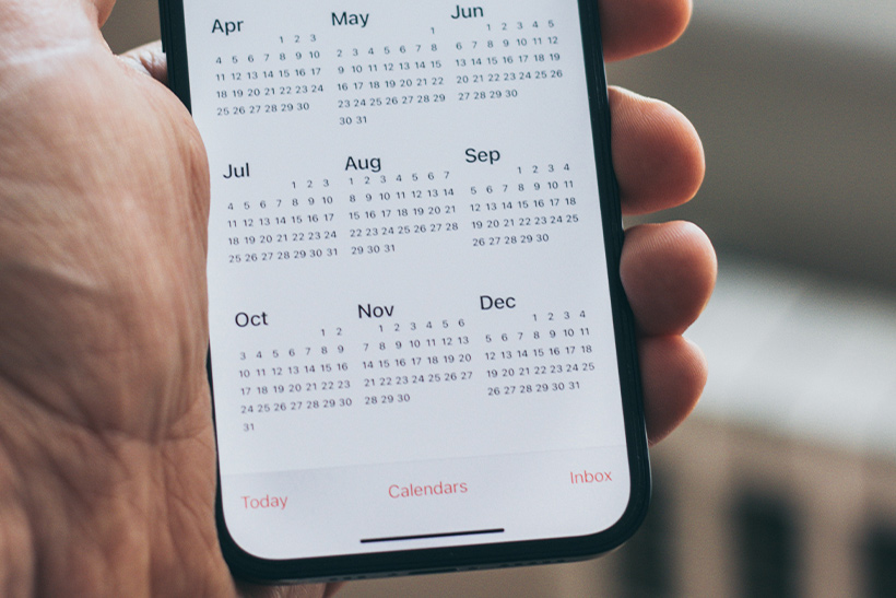 Man Holds Phone With A Calendar App Open