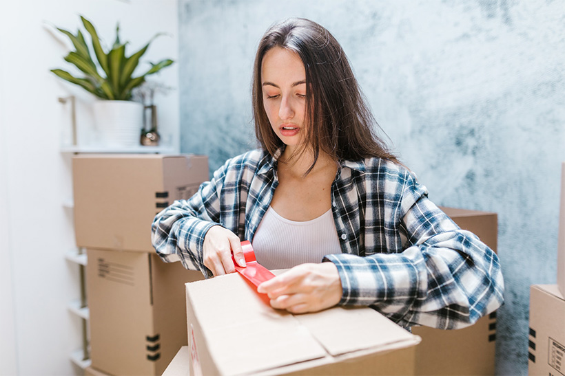 A Girl Is Packing Pillows Into Cardboard Boxes