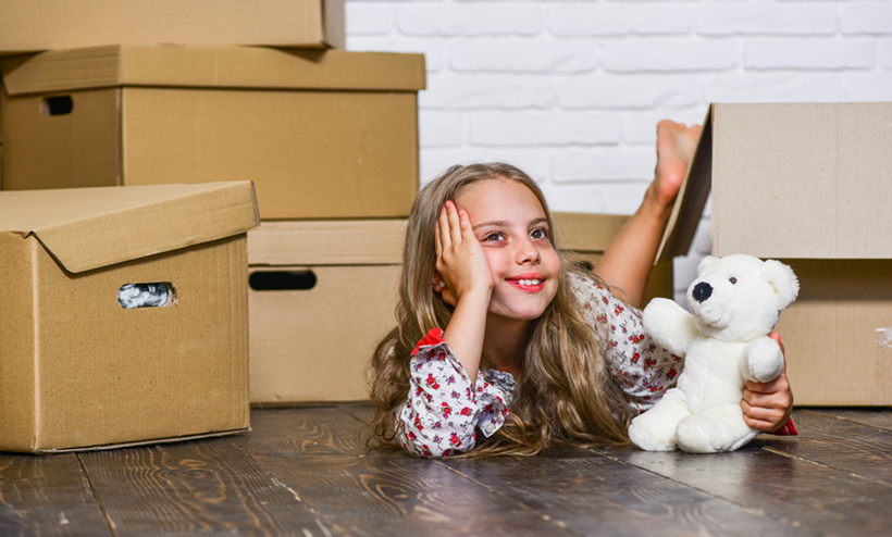 A Happy Kid With a New Toy During a Move