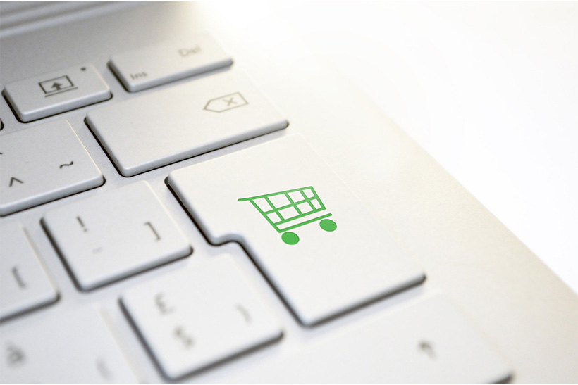 A Laptop Keyboard With A Printed Shopping Cart On An Enter Key