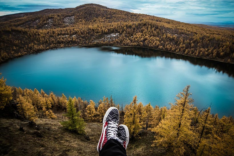 Girl Is Sitting Above A Mountain Lake