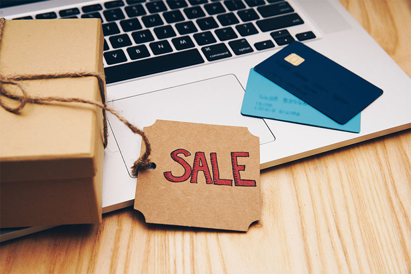 Laptop With A Sale Sign And A Couple Of Credit Cards In The Background