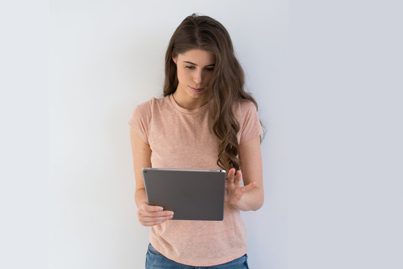 a girl is browsing online on a tablet