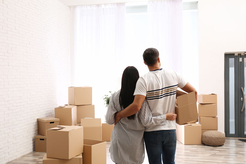 A Couple Looking at the Moving Boxes Before the Move