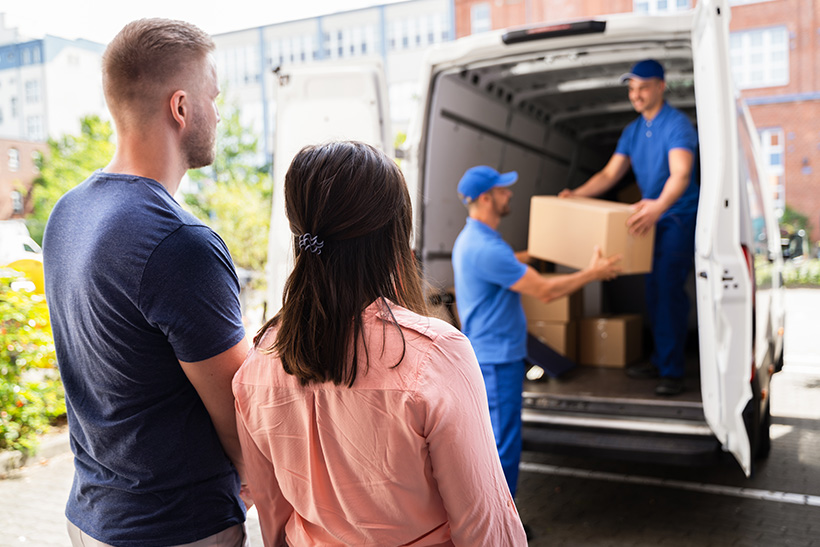 A couple watches movers loading a truck