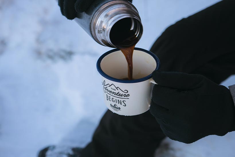 A Man Drinks Hot Coffee At The Snow