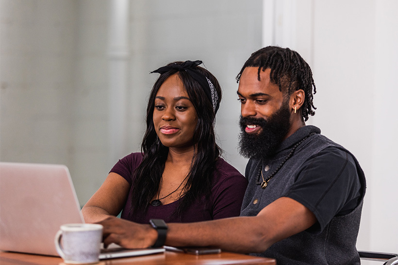 A Couple Is Searching The Web On A Laptop