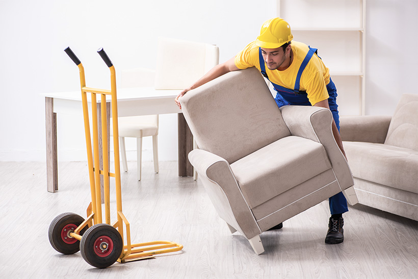 A Mover Is Loading a Chair on a Moving Dolly