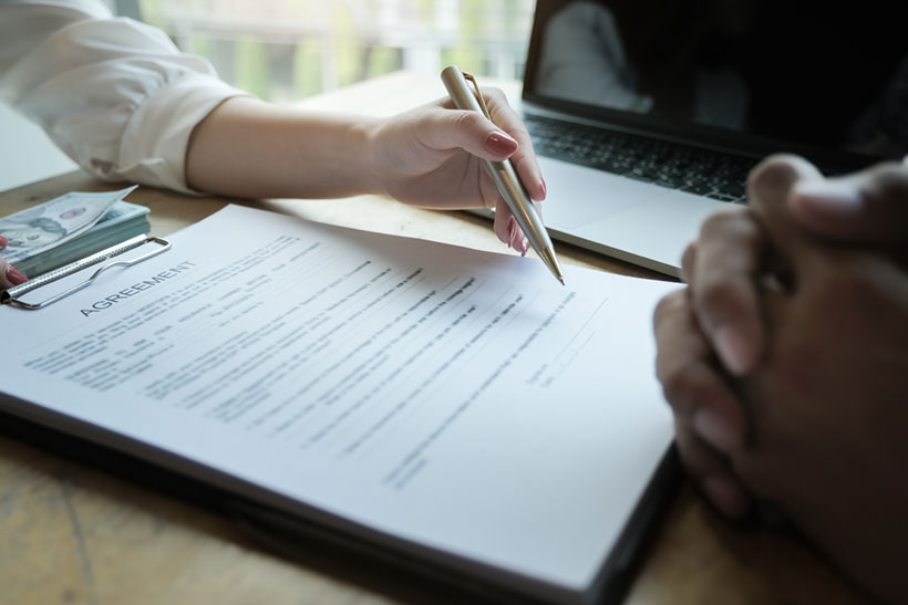 A Customer Is Signing The Moving Insurance Form