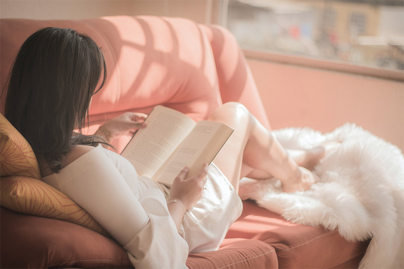 A Woman Reads Book Lying In A Bed