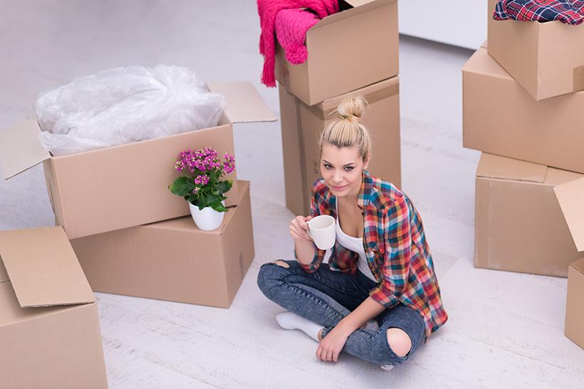 A Woman Drinks Coffee During Packing for a Move